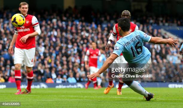 Sergio Aguero of Manchester City scores the opening goal during the Barclays Premier League match between Manchester City and Arsenal at Etihad...