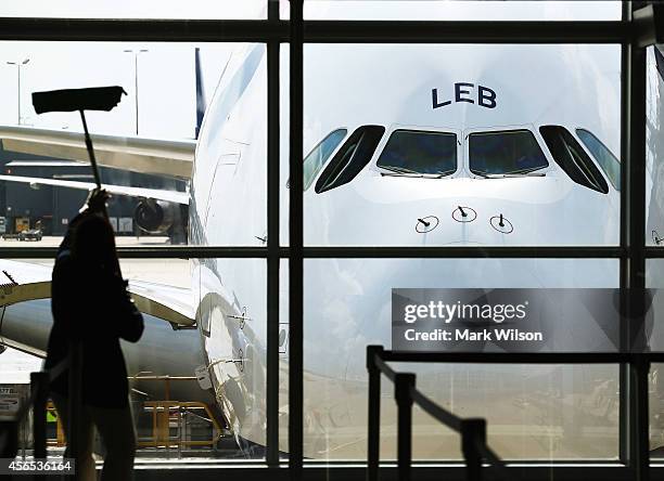 Worker cleans the windows in front of British Airways' new super jumbo Airbus A380 after it arrived at Washington Dulles International Airport...