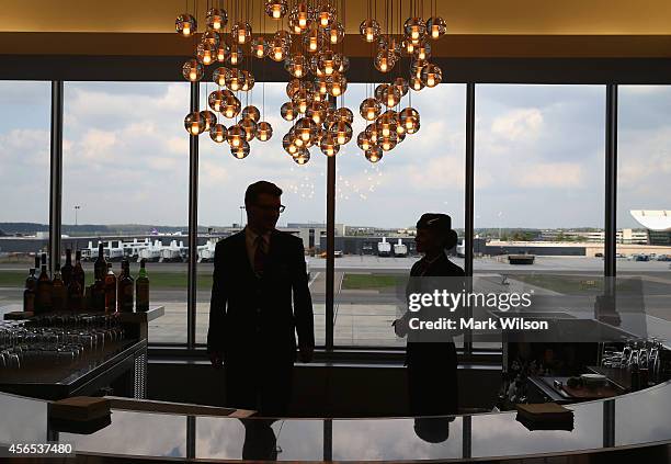 British Airways Flight Attendants Claire Parsons and Sam Pritchard stand a bar in the new British Airways new lounge at Washington Dulles...