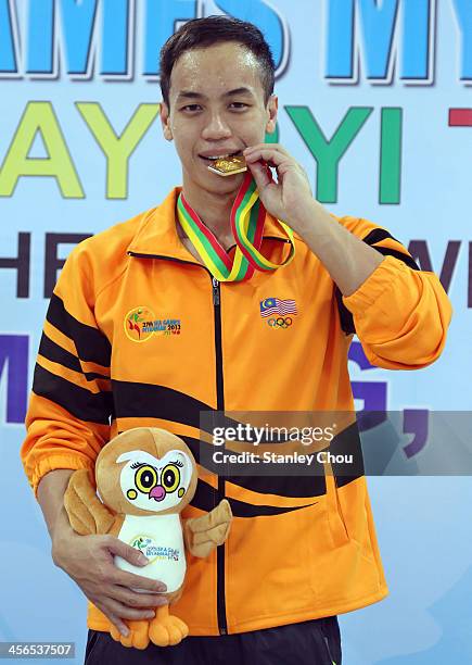 Daniel William Henry Bego of Malaysia kisses his gold medal after he won the Men's 400m Freestyle Final during the 2013 SEA Games at the Wunna...