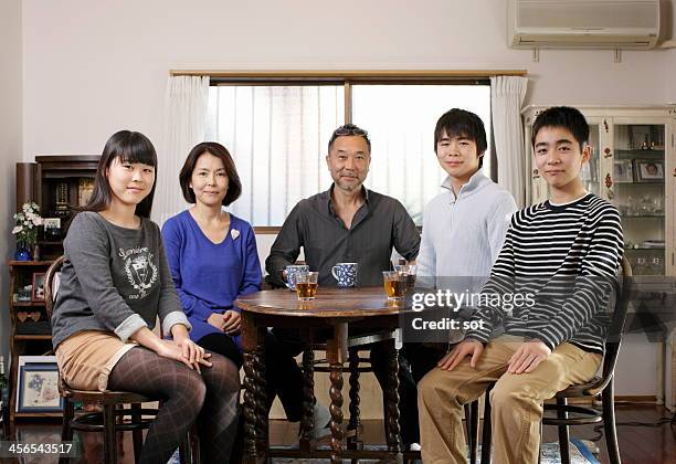 portrait of japanese family - sitting at table looking at camera stock-fotos und bilder