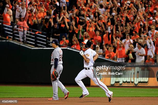 Hardy of the Baltimore Orioles rounds the bases passing Miguel Cabrera of the Detroit Tigers after hitting a solo home run in the seventh inning...