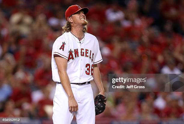 Jered Weaver of the Los Angeles Angels reacts after walking Mike Moustakas of the Kansas City Royals in the third inning during Game One of the...