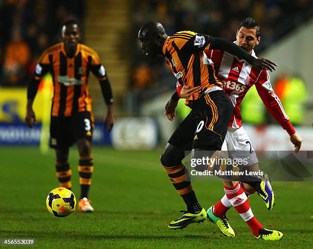 Yannick Sagbo of Hull City holds off the challenge of Geoff Cameron of Stoke City during the Barclays Premier League match between Hull City and...