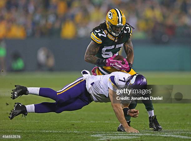 Christian Ponder of the Minnesota Vikings tackles Jamari Lattimore of the Green Bay Packers after an interception at Lambeau Field on October 2, 2014...