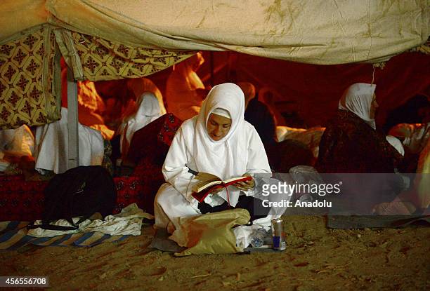 Muslim Pilgrim woman reads the Quran, Islam's holy book, near the Mount Arafat on the plain of Arafat ahead of the hajj main ritual in Mecca, Saudi...