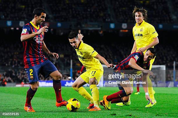 Hernan Perez of Villarreal CF duels for the ball with Martin Montoya and Alexis Sanchez of FC Barcelona during the La Liga match between FC Barcelona...