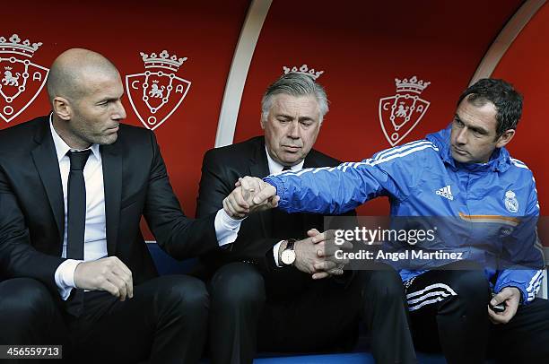 Head coach Carlo Ancelotti of Real Madrid looks on as his assistants Zinedine Zidane and Paul Clement shake hands during the La Liga match between CA...