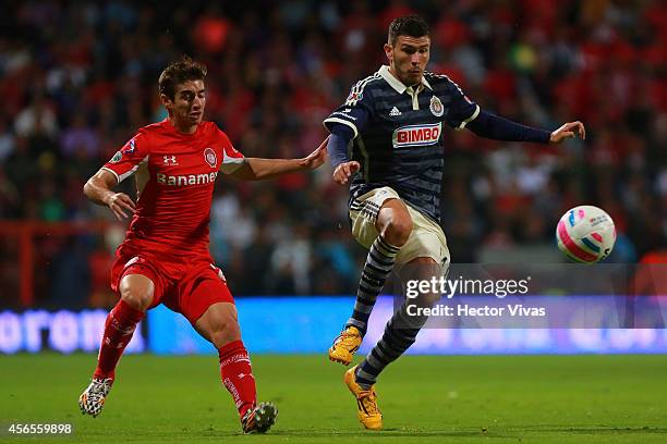 Isaac Brizuela of Toluca struggles for the ball with Jorge Enriquez of Chivas during a match between Toluca and Chivas as part of 11th round Apertura...