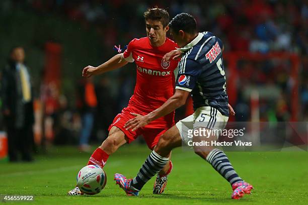 Isaac Brizuela of Toluca struggles for the ball with Patricio Araujo of Chivas during a match between Toluca and Chivas as part of 11th round...