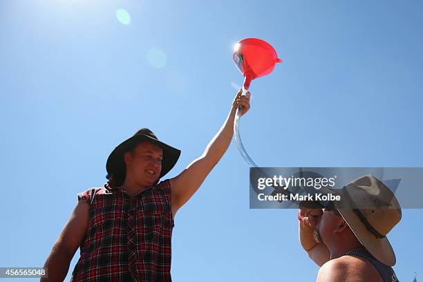 Camper drinks rum from a beer bong in the "Ute Paddock" as they enjoy the atmosphere on the first day of the 2014 Deni Ute Muster at the Play on the...