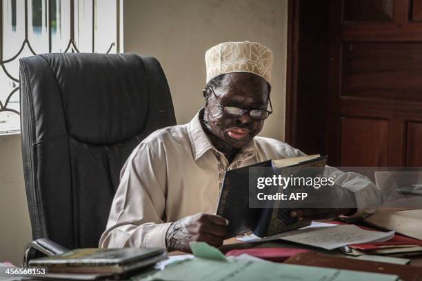 Moderate muslim cleric Sheikh Fadhil Soraga, who was injured in an acid attack last year, reads in Zanzibar on November 17, 2013. This popular...