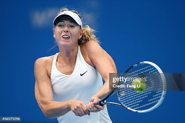 Maria Sharapova of Russia returns a shot against Svetlana Kuznetsova of Russia during day seven of the China Open at the National Tennis Center on...