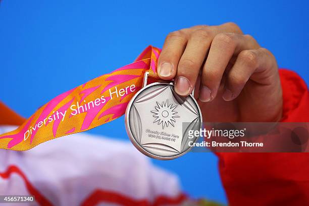 Silver medalist, Yang Jian of China holds his medal atop the podium following the Men's 10m Platform Final during day fourteen of the 2014 Asian...