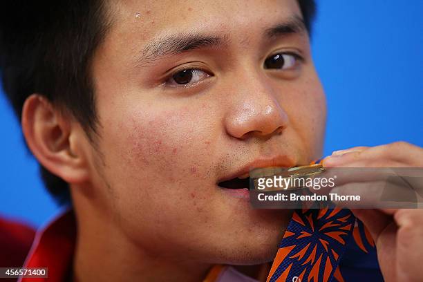 Gold medalist, Qiu Bo of China celebrates atop the podium following the Men's 10m Platform Final during day fourteen of the 2014 Asian Games at...