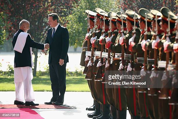 Britain's Prime Minister David Cameron is welcomed to the Presidential Palace by Afghanistan's President Ashraf Ghani on October 3, 2014 in Kabul,...