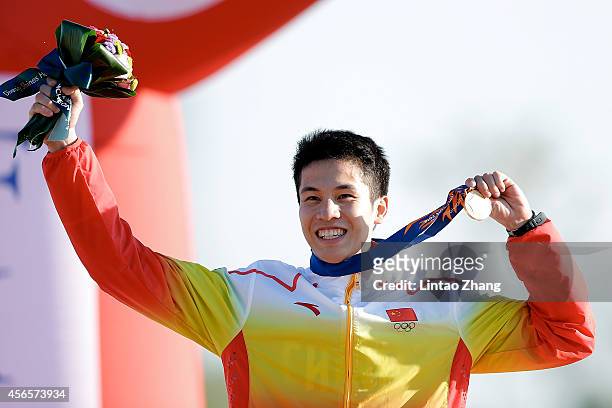 Gold medalist Guo Jianli of China celebrates during the medal ceremony after the Men's Individual Combined Pentathlonin day fourteen of the 2014...