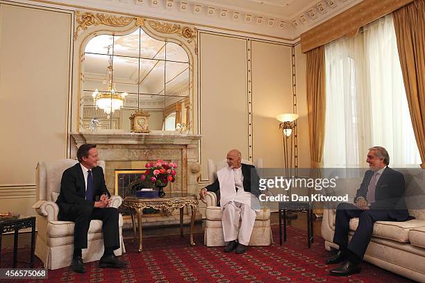 Britain's Prime Minister David Cameron talks with President Ashraf Ghani and Chief Executive Officer Abdullah Abdullah during a trilateral meeting at...