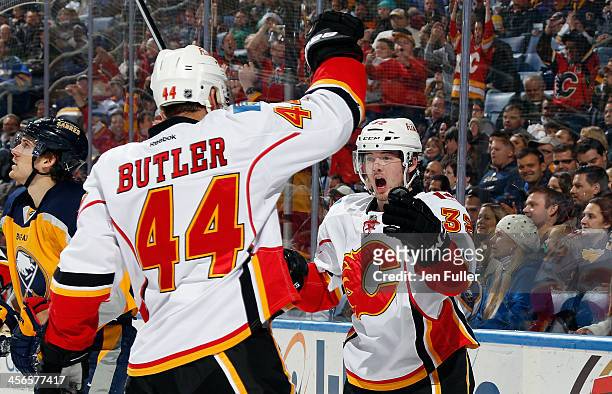 Paul Byron of the Calgary Flames celebrates his third period goal against the Buffalo Sabres with teammate Chris Butler at First Niagara Center on...