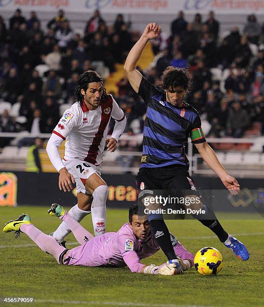 Diego Mainz Garcia and goalkpeeper Roberto Fernandez of Granada CF clear the ball while being challenged by Joaquin Larrivey of Rayo Vallecano de...