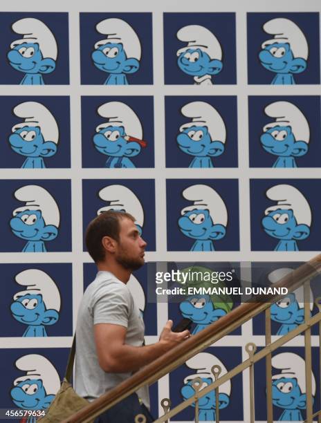 Visitor walks past a panel exhibiting characters from the Belgian comic series "The Smurfs" created by Belgian cartoonist Peyo , in the "Centre Belge...