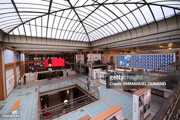 Visitors tour the "Centre Belge de la Bande Dessinee" , with a panel showing "The Smurfs" by Belgian cartoonist Peyo on October 3, 2014 in Brussels,...