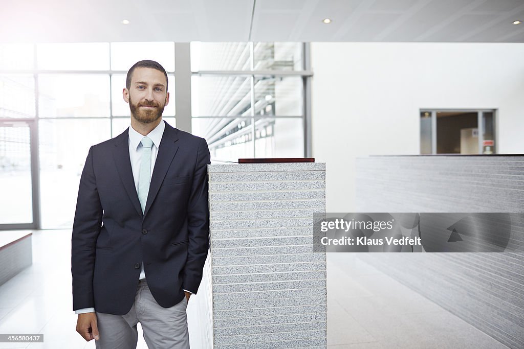 Portrait of creative businessman, standing in hall