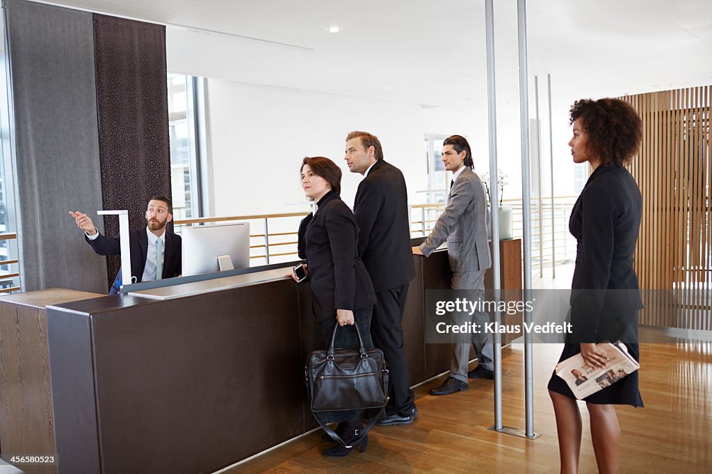 Man in reception helping guests with directions