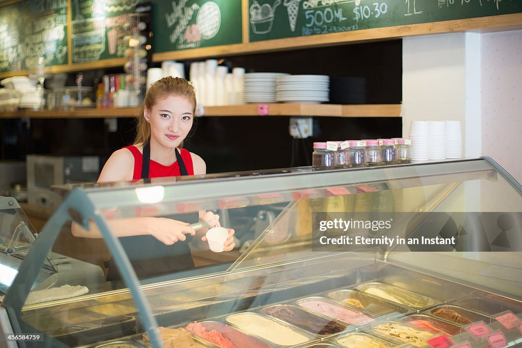 Young woman working in ice cream shop.