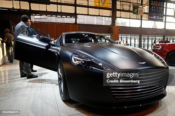 An Aston Martin badge sits on the hood of an Aston Martin Rapide S automobile, produced by Aston Martin Lagonda Ltd., at the Paris Motor Show on the...