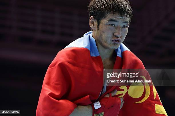 Otgondalai Dorjnyambuu of Mongolia drapes himself with the country flag after his win over Charly Suarez of Philippines during the men's boxing...
