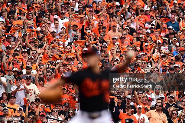 Fans cheer as Wei-Yin Chen of the Baltimore Orioles throws a pitch in the second inning against the Detroit Tigers during Game Two of the American...