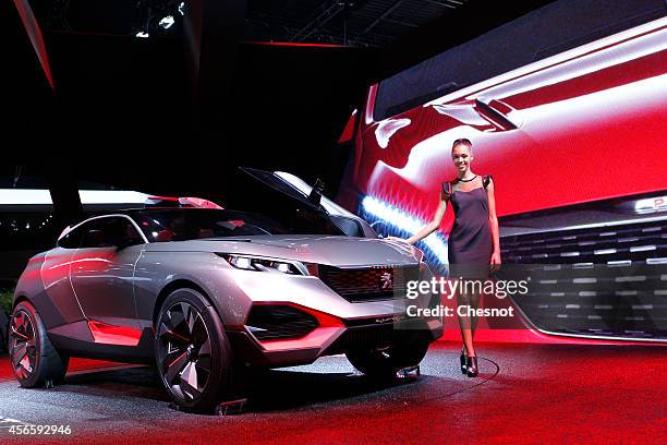 Model poses next a Peugeot concept car Quartz during the second press day of the Paris Motor Show on October 03 in Paris, France. The Paris Motor...