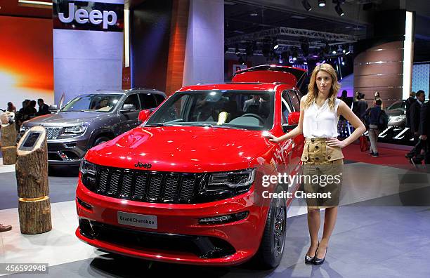 Model poses next a Jeep Grand Cherokee during the second press day of the Paris Motor Show on October 03 in Paris, France. The Paris Motor Show will...