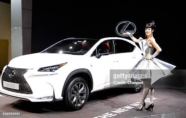 Model poses next a Lexus NX 200i during the second press day of the Paris Motor Show on October 03 in Paris, France. The Paris Motor Show will...