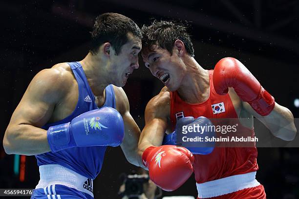 Kim Hyeongkyu of South Korea fights Adilbek Niyazymbetov of Kazakhstan during the men's light heavy weight bout final on day fourteen of the 2014...
