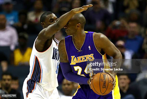 Ben Gordon of the Charlotte Bobcats guards Kobe Bryant of the Los Angeles Lakers during their game at Time Warner Cable Arena on December 14, 2013 in...