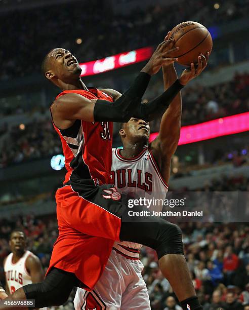 Jimmy Butler of the Chicago Bulls knocks the ball away from Terrence Ross of the Toronto Raptors at the United Center on December 14, 2013 in...