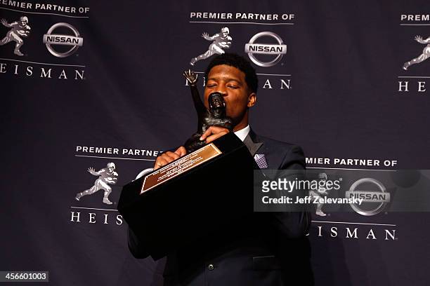 Jameis Winston, quarterback of the Florida State Seminoles, kisses the trophy during a press conference after the 2013 Heisman Trophy Presentation at...