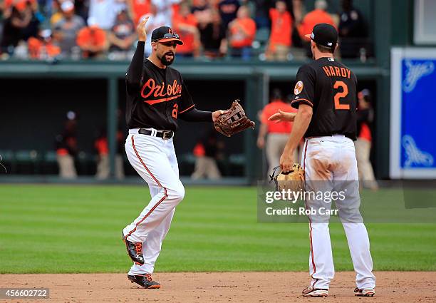 Nick Markakis of the Baltimore Orioles celebrates with J.J. Hardy after defeating the Detroit Tigers 7 - 6 in Game Two of the American League...
