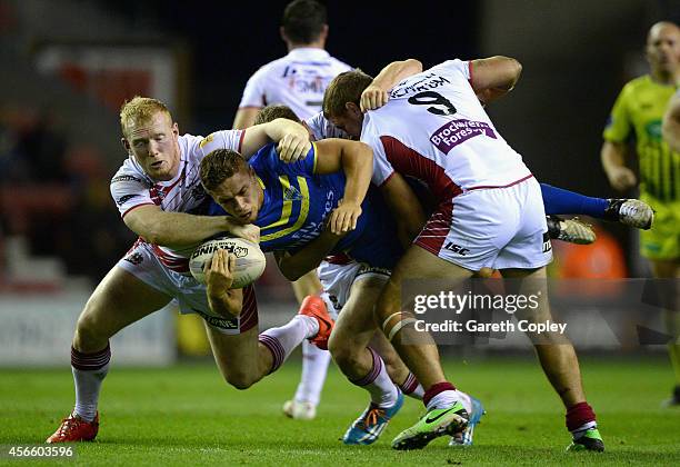 Matty Russell of Warrington Wolves is tackled by Liam Farrell and Michael McIlorum of Wigan Warriors during the First Utility Super League Qualifying...