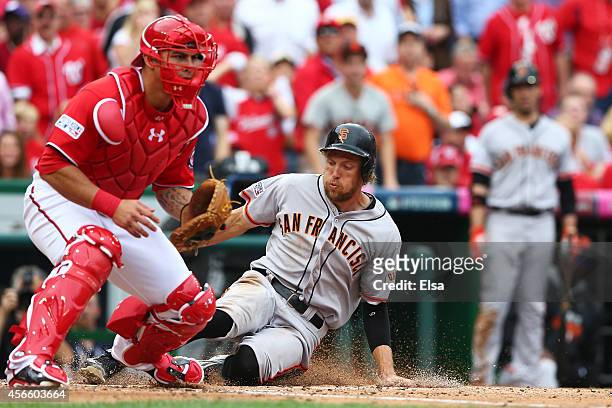 Hunter Pence of the San Francisco Giants slides home to score on a single by Brandon Belt in the fourth inning against the Washington Nationals...