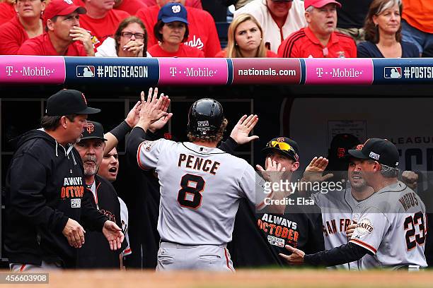 Hunter Pence of the San Francisco Giants is welcomed to the dugout after scoring on a single by Brandon Belt in the fourth inning against the...