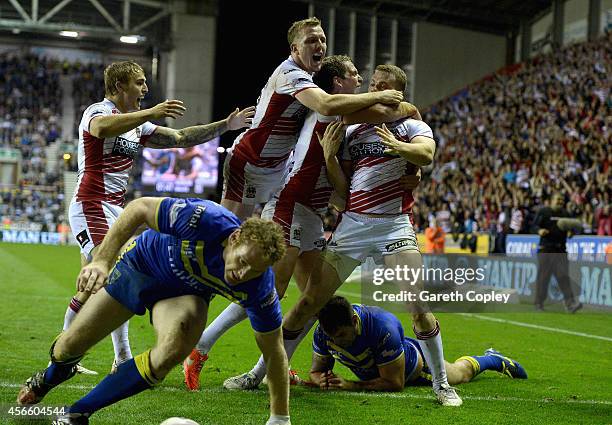 Joe Burgess of Wigan Warriors is mobbed by teammates after scoring the winning try past during the First Utility Super League Qualifying Semi-Final...