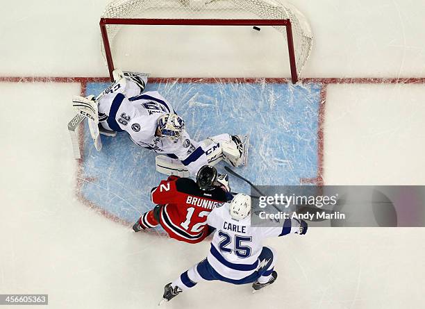 Damien Brunner of the New Jersey Devils puts the puck past Anders Lindback of the Tampa Bay Lightning for the game-winning goal during the game at...