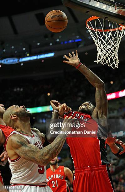 Carlos Boozer of the Chicago Bulls grabs the jersey Amir Johnson of the Toronto Raptors as he tries for a rebound at the United Center on December...