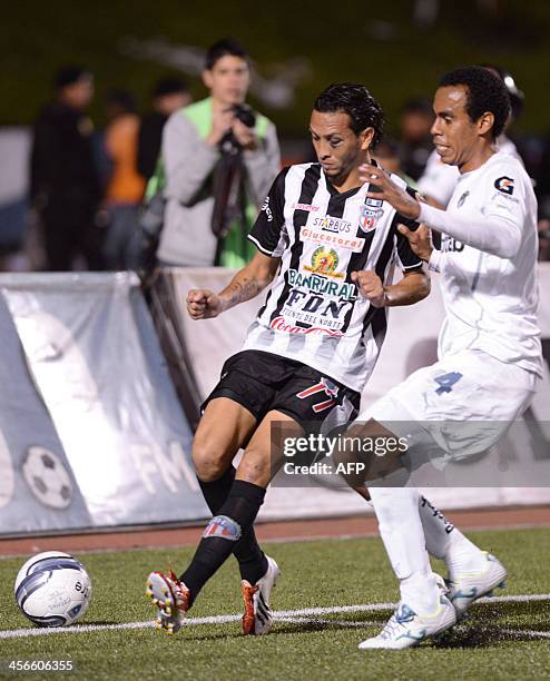 Heredia's Osmar Lopez vies for the ball with Comunicacione's Wilson Lalin during the 2013 Aperture Tournament final football match at Cementos...