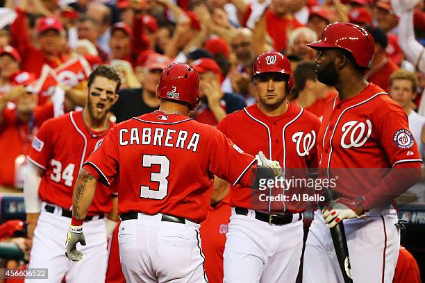Asdrubal Cabrera of the Washington Nationals celebrates his in the seventh inning home run with teammates during Game One of the National League...