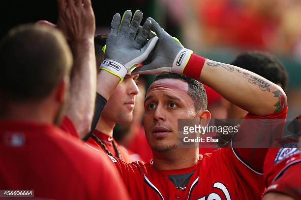Asdrubal Cabrera of the Washington Nationals celebrates his in the seventh inning home run with teammates during Game One of the National League...