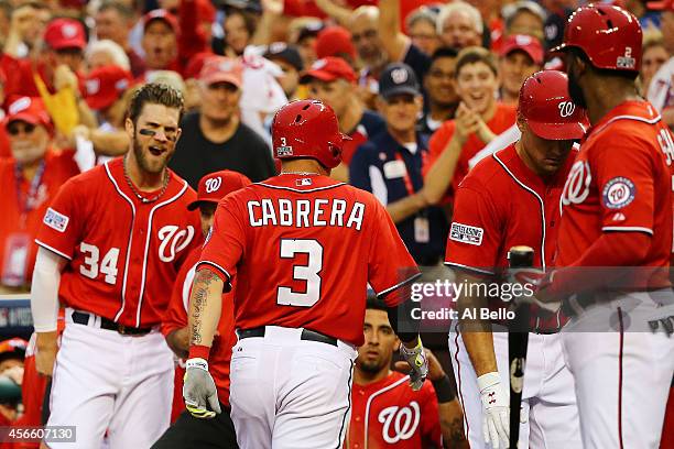 Asdrubal Cabrera of the Washington Nationals celebrates his in the seventh inning home run with teammates during Game One of the National League...